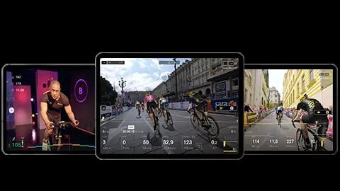 Rouleau de cyclisme d'intérieur à côté d'une tablette avec l'application virtuelle de cyclisme d'intérieur de BKOOL