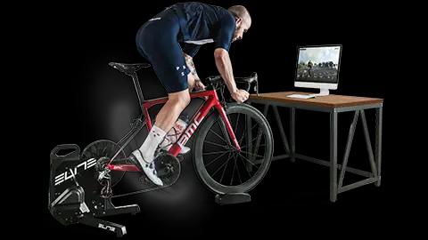 Ciclista che si allena su un rullo con l'aiuto del software di indoor cycling di BKOOL