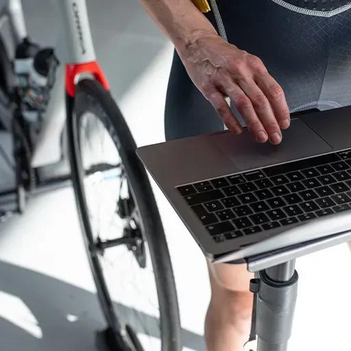 Ciclista che accede al simulatore virtuale di bicicletta BKOOL sul suo computer.