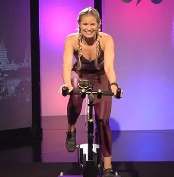 Istruttore di simulatore di ciclismo BKOOL che tiene una lezione di indoor cycling