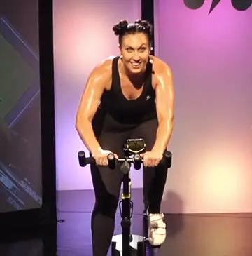 Istruttore di simulatore di ciclismo BKOOL che tiene una lezione di indoor cycling